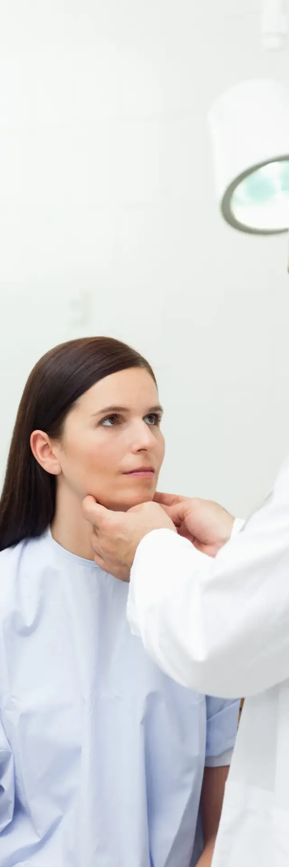 Doctor touching the neck of a patient in an examination room